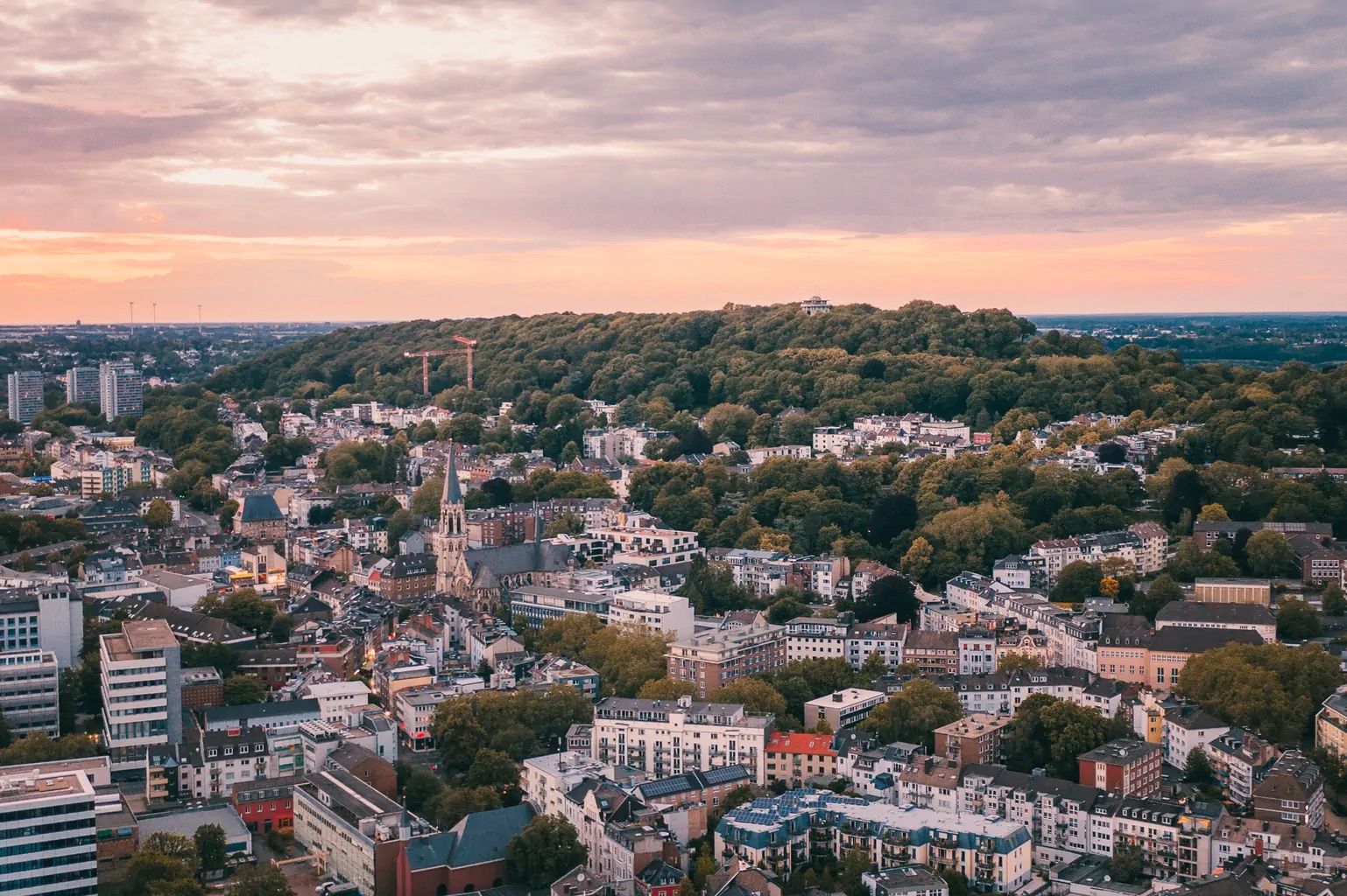 Luftaufnahme von Aachen mit dem Lousberg in der Abenddämmerung